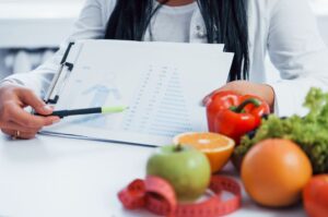 Ernährungsberaterin sitzt mit Plan am Tisch